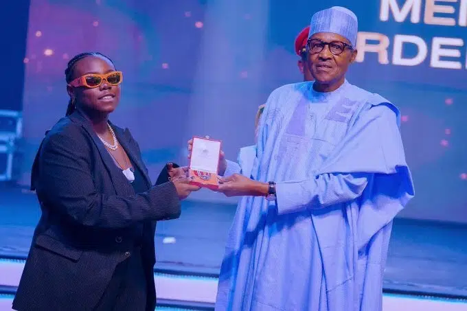 Orobo with zero sense – DSS DG’s son slams Teni for not bowing to President Buhari while receiving her MON award